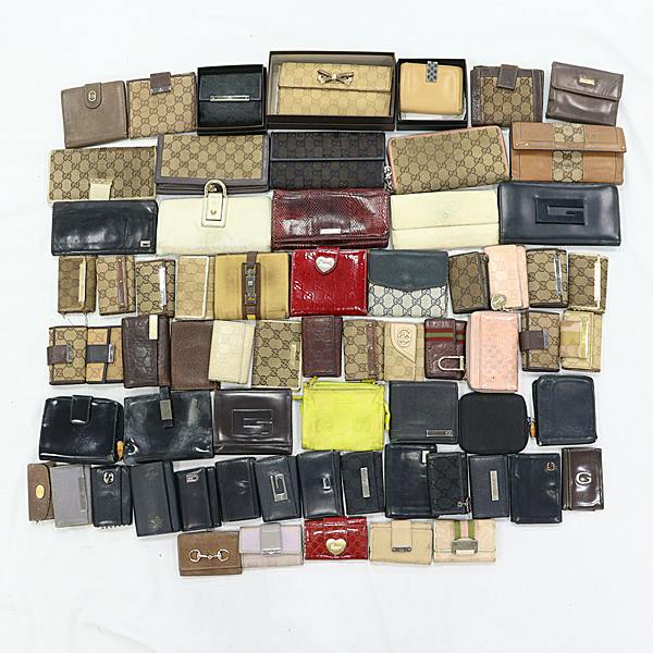 A large assortment of Gucci wallets and small leather goods arranged on a white background.