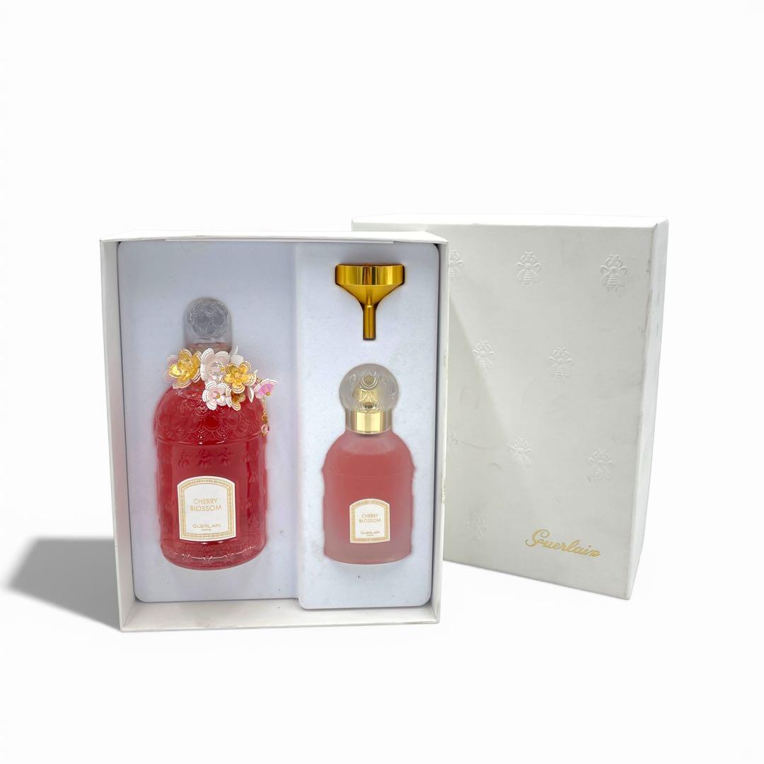 Boxed GUERLAIN Cherry Blossom eau de toilette set showing two bottles and a small funnel with the white outer box visible.