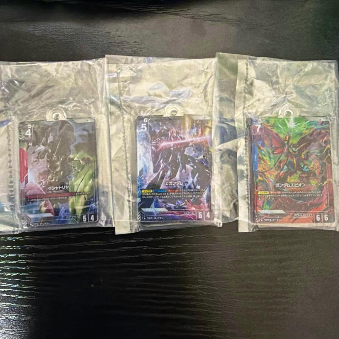 Three Gundam acrylic keychain charms in sealed plastic bags showing artwork for クシャトリヤ, Z, and エピオン.