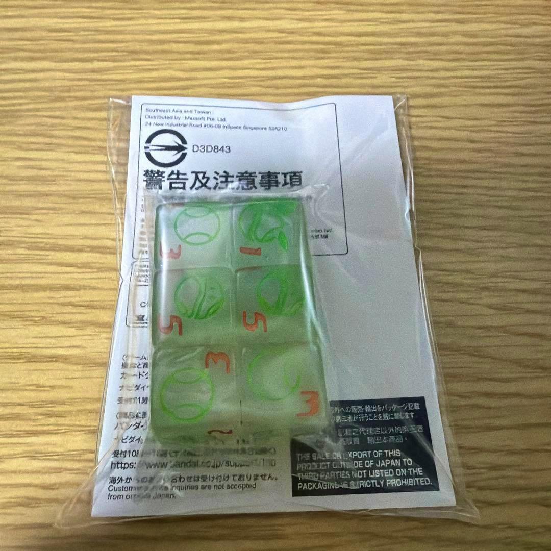 Packaged translucent green Haro-themed damage counter dice in a clear plastic bag with a paper insert on a wooden surface.