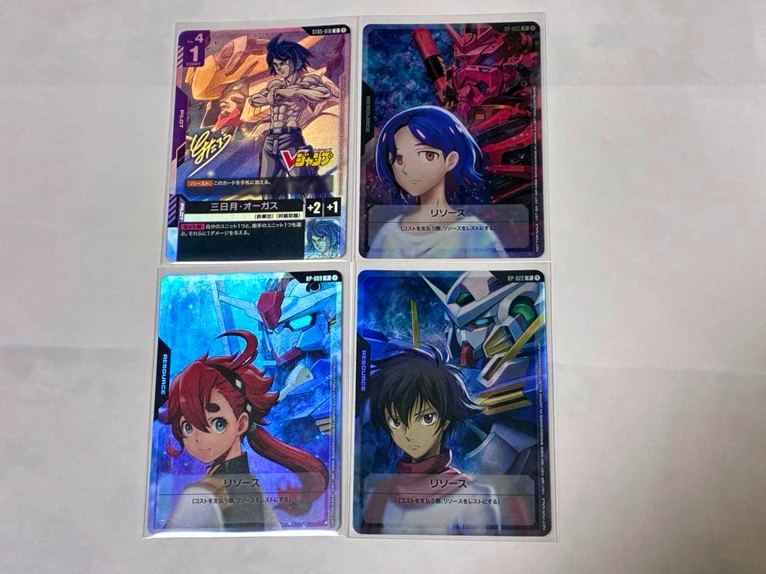 Four Gundam trading cards displayed front-side in clear sleeves on a white background.