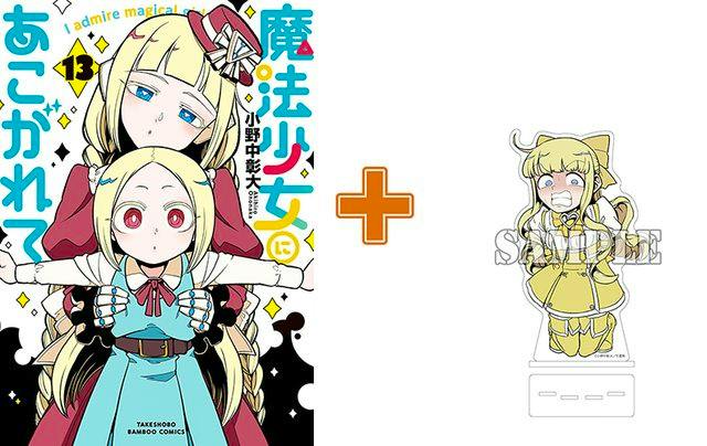 Comic book cover for "魔法少女にあこがれて(13)" shown alongside an acrylic character stand.