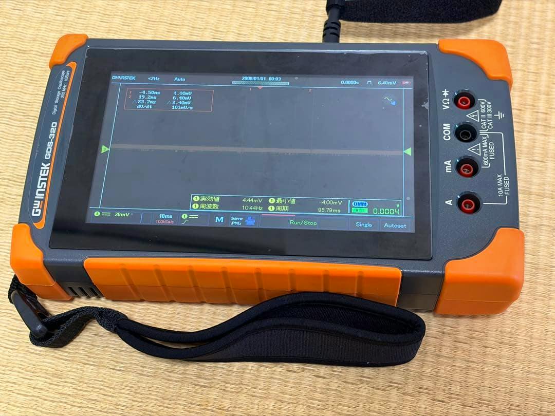 GW INSTEK GDS-320 oscilloscope laid flat showing its touchscreen display and front input jacks.