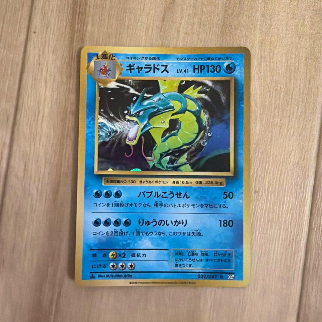 Front of the ギャラドス R CP6 20th Anniversary trading card (032/087) photographed on a wooden surface.