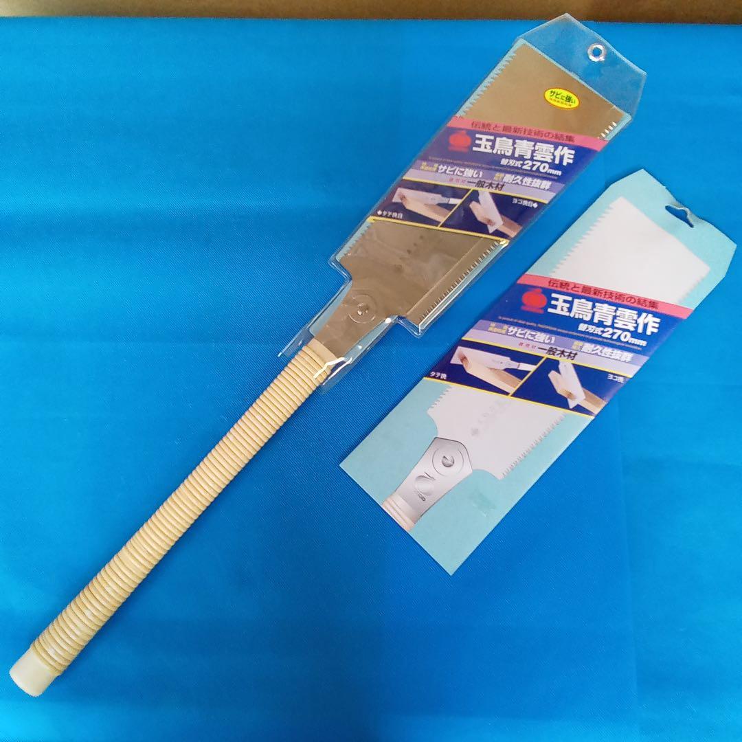 Double-edged 270mm Tamatori saw with wrapped handle and replacement blade pack on a blue background.