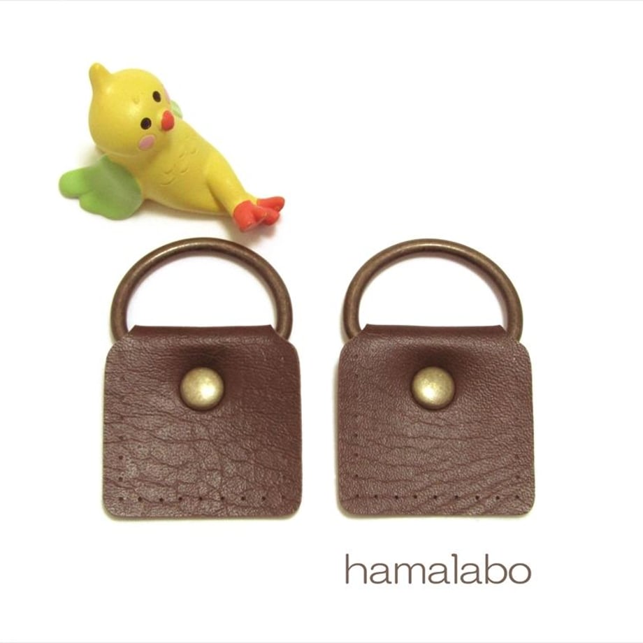 Two brown cow-leather shoulder-bag attachments (large) with metal D-rings and brass snaps shown on a white background.