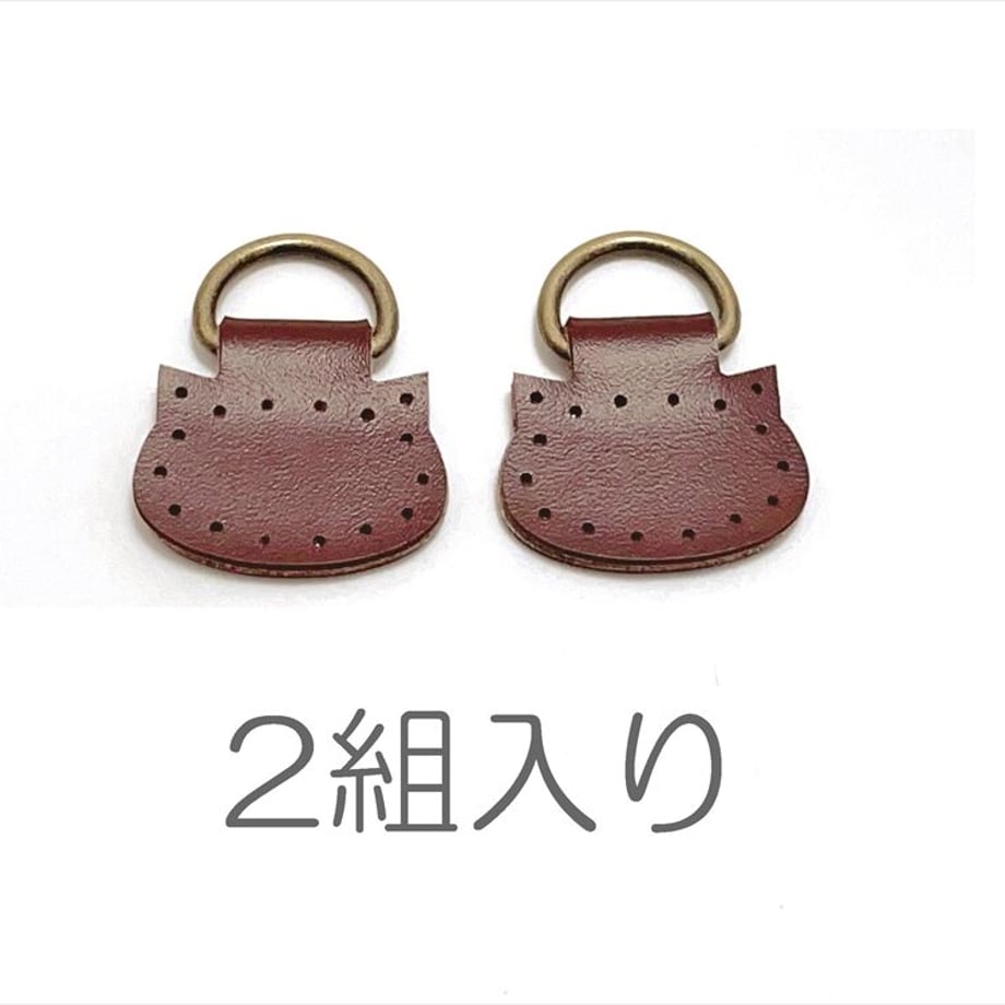 Two cat-shaped cow-leather shoulder-bag attachments with metal rings shown on a white background with the text "2組入り".