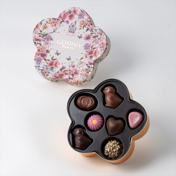 Open flower-shaped box with a floral-patterned lid and seven assorted chocolates visible in the tray.