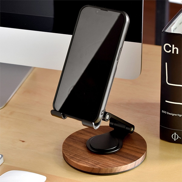 Adjustable folding purpleheart wooden smartphone stand holding a smartphone on a desk.