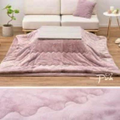 Pink kotatsu blanket (futon) draped around a low table in a living room setting.