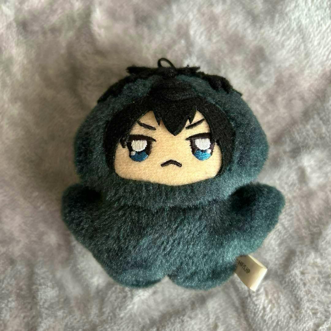 Green plush mascot of Kageyama Tobio from Haikyuu with an embroidered face photographed on a gray surface.