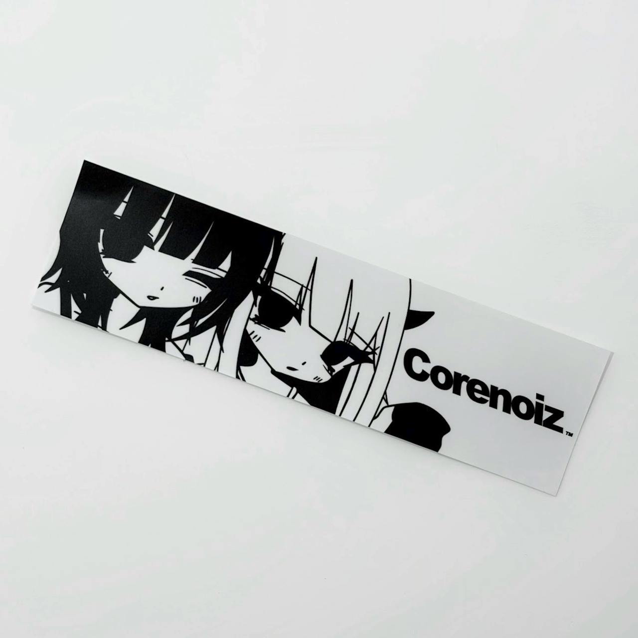 A white rectangular sticker showing black anime-style faces and the text "Corenoiz".
