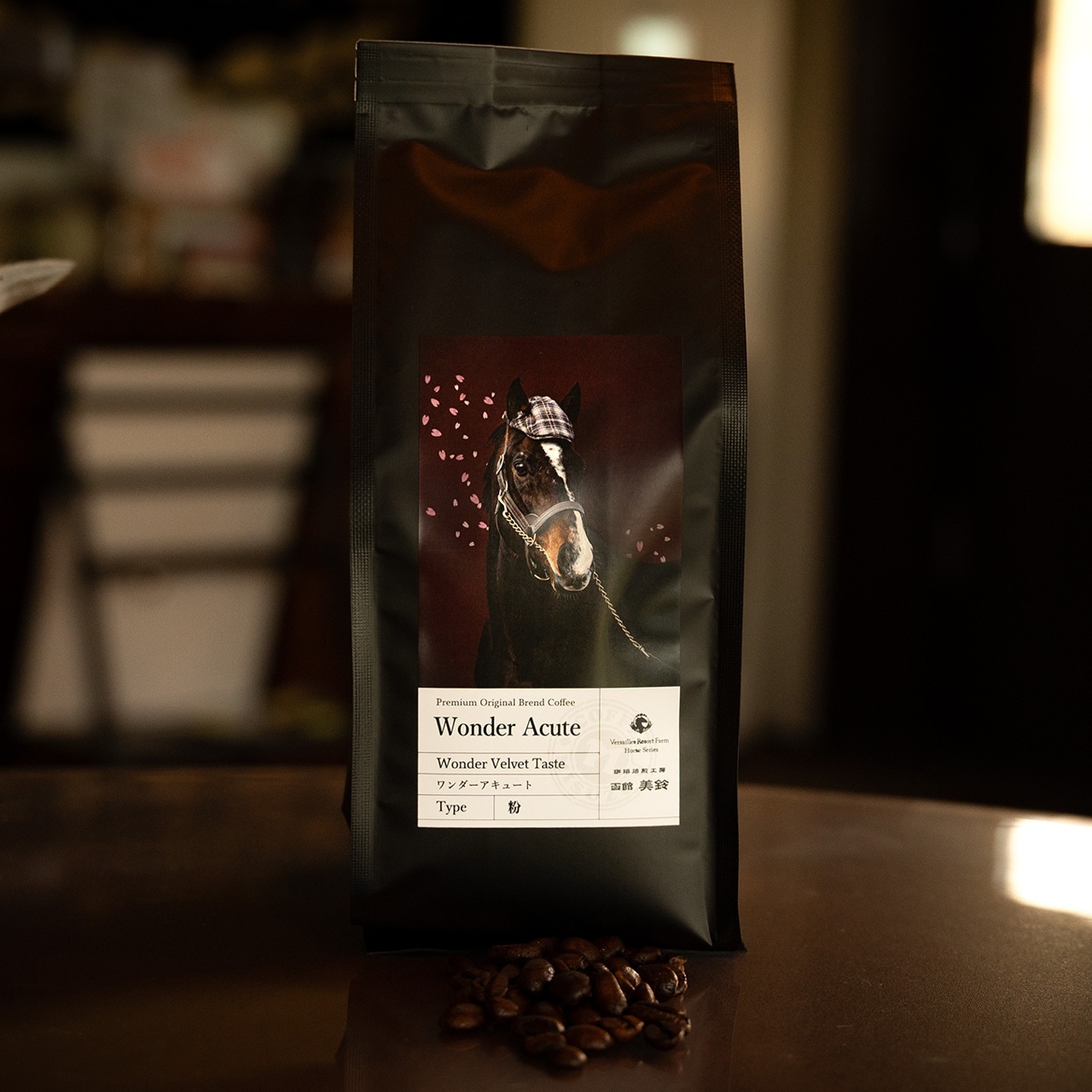Black bag of "Wonder Acute" roasted coffee with a horse label displayed on a table with a few coffee beans in front.