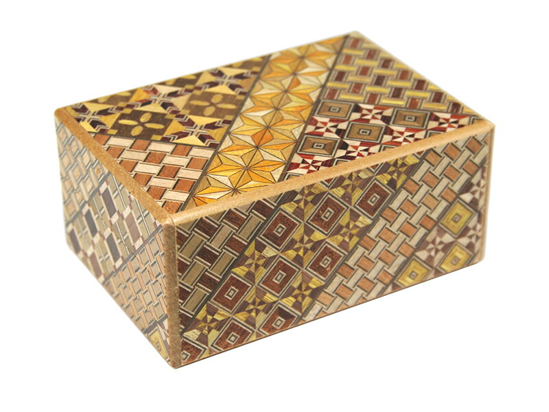 A rectangular Hakone yosegi wooden box showing multicolored geometric marquetry patterns on the top and sides.