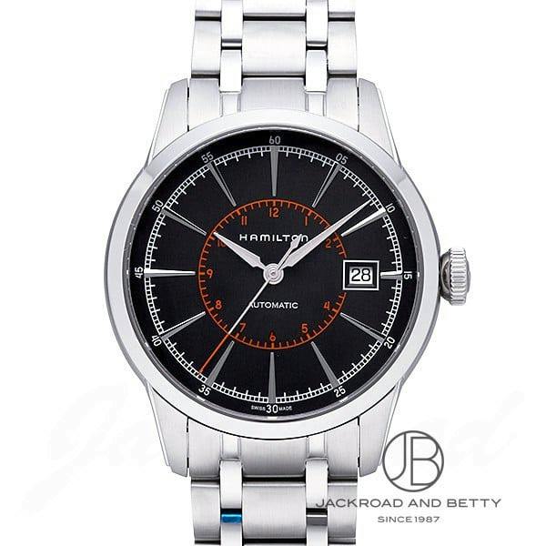 Front view of the Hamilton RailRoad Auto watch showing a non-precious-metal case and bracelet, black dial with an orange inner 12-hour ring, date at 3 o'clock, and three hands.