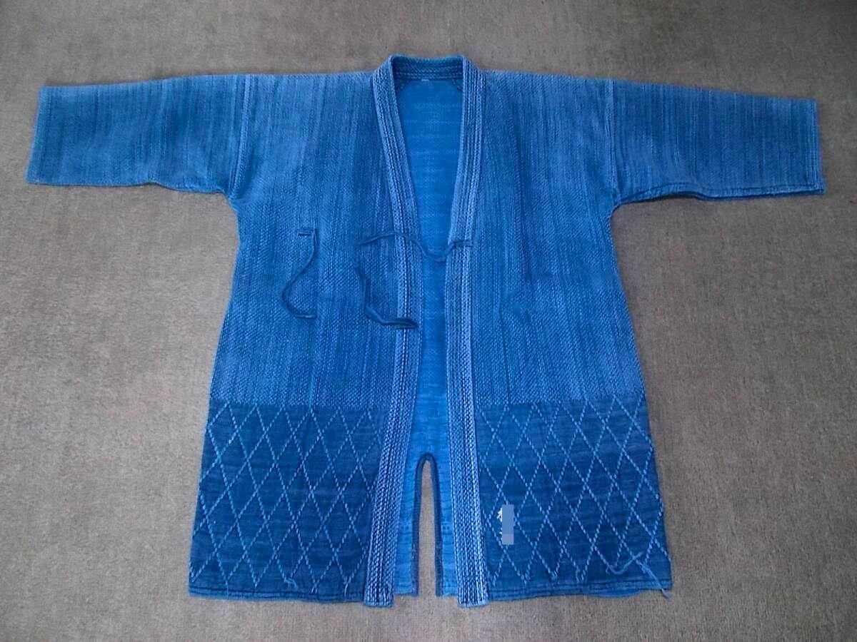 Front view of an indigo-dyed kendo jacket (kendogi) laid flat with sleeves extended.