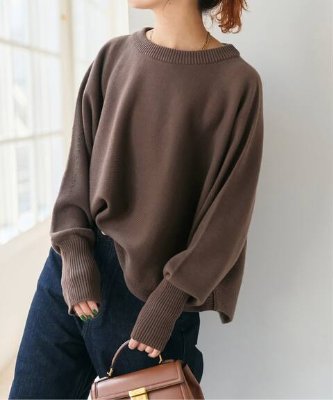 Model wearing a brown dolman long-rib knit sweater shown from torso to hips, with ribbed neckline and long cuffs.