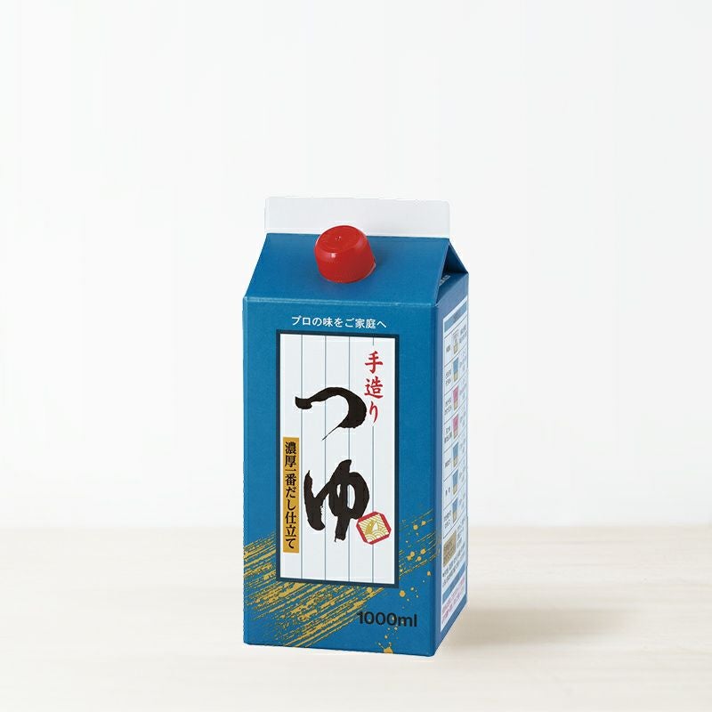 A blue carton of tsuyu (soy sauce) with a red screw cap on a white surface.
