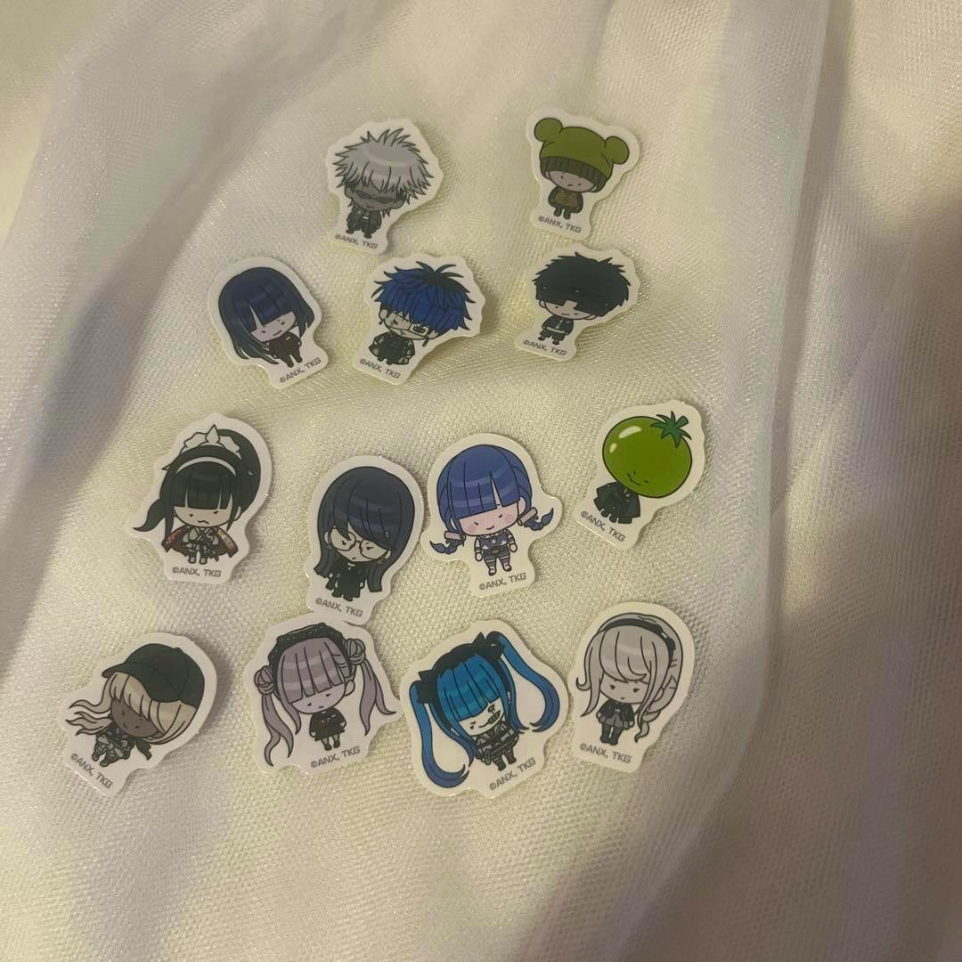 Several mini flake chibi (deformed) character stickers arranged on a white fabric background.