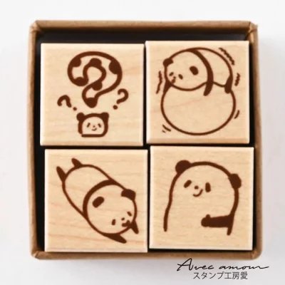 Four small square wooden stamps with animal illustrations displayed in a cardboard box.