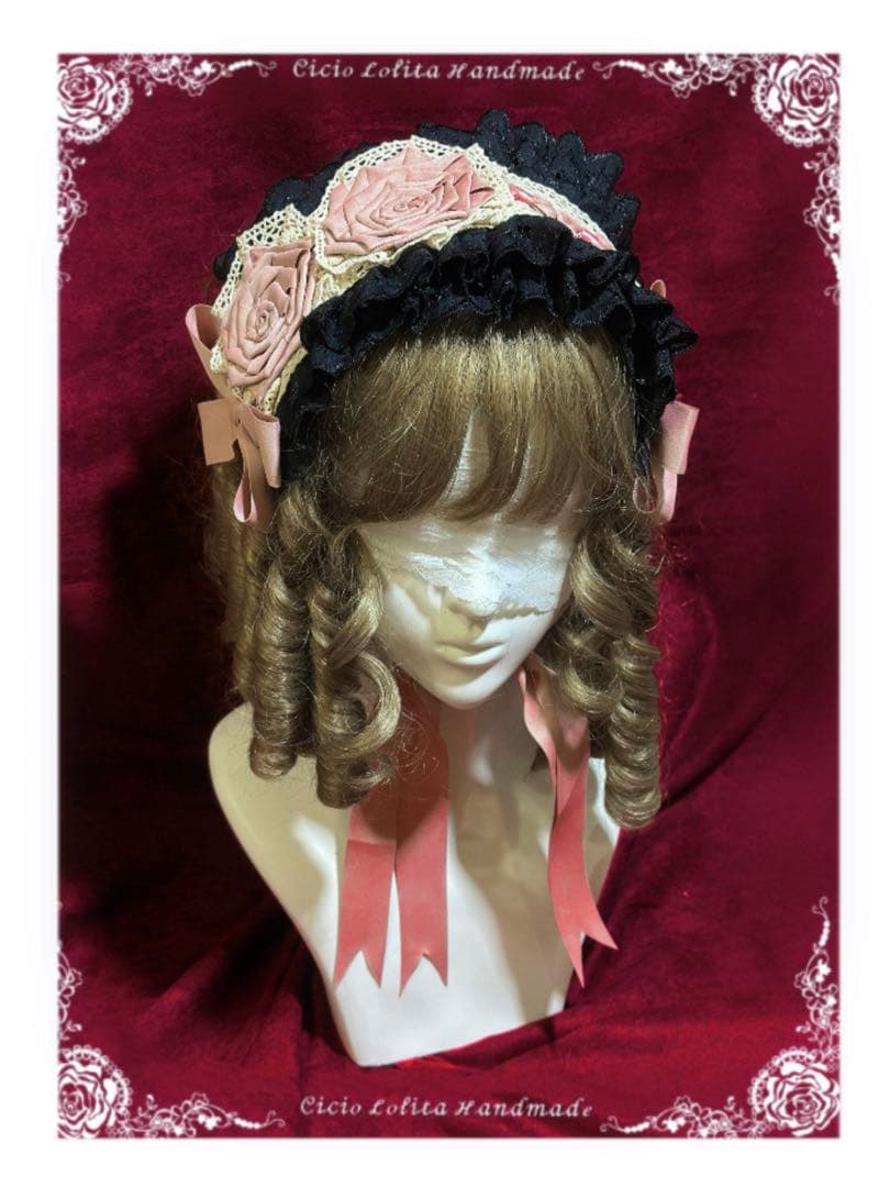 Mannequin head wearing a black-and-pink handmade rose doll headband with lace trim and long pink ribbons.