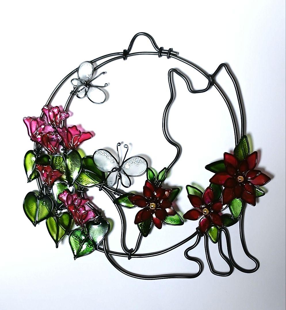 Wire and aluminum wall decoration depicting a cat silhouette with cyclamen-style flowers and two butterflies in a circular frame.