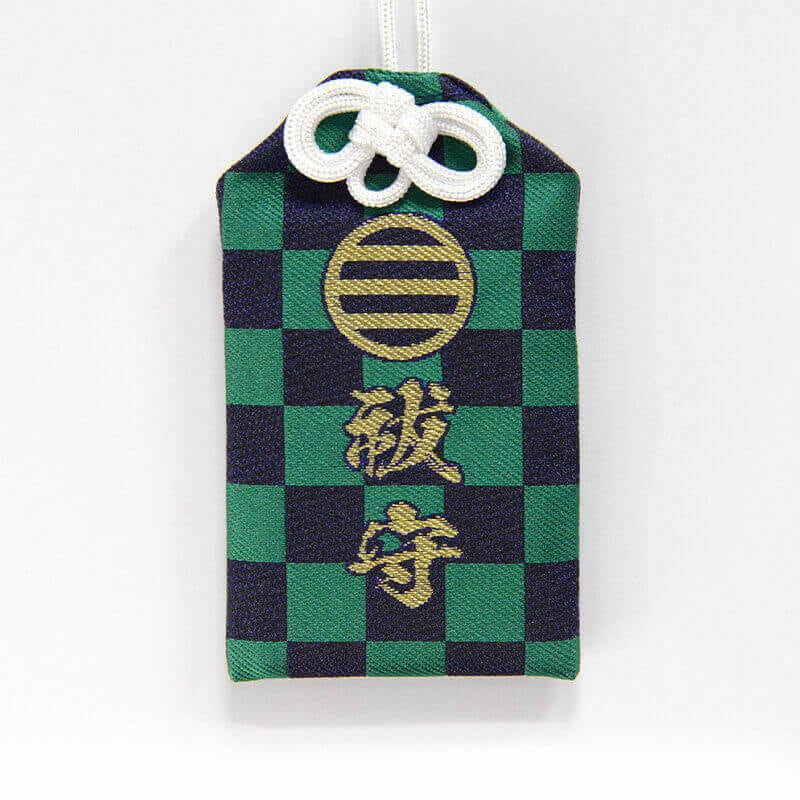 Green and black checkered cloth amulet with gold embroidered characters and a white cord.