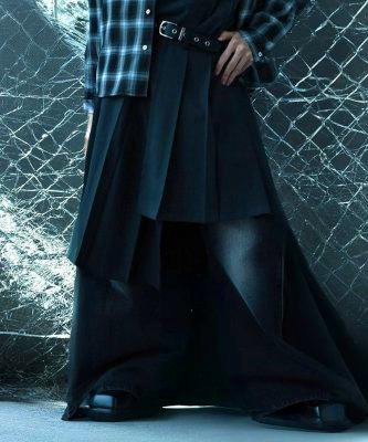 A model wearing the wrap skirt belt fastened around the waist over a pleated skirt and wide pants.