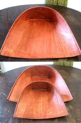 Large wooden curved tray with a rectangular hole near the top edge, shown on a dark table.