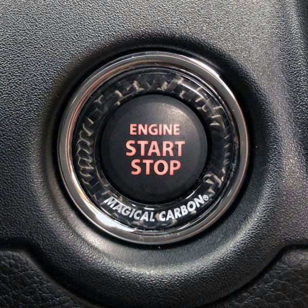 Close-up of a vehicle engine start/stop button with a Magical Carbon decorative ring (NEO TYPE B) installed.