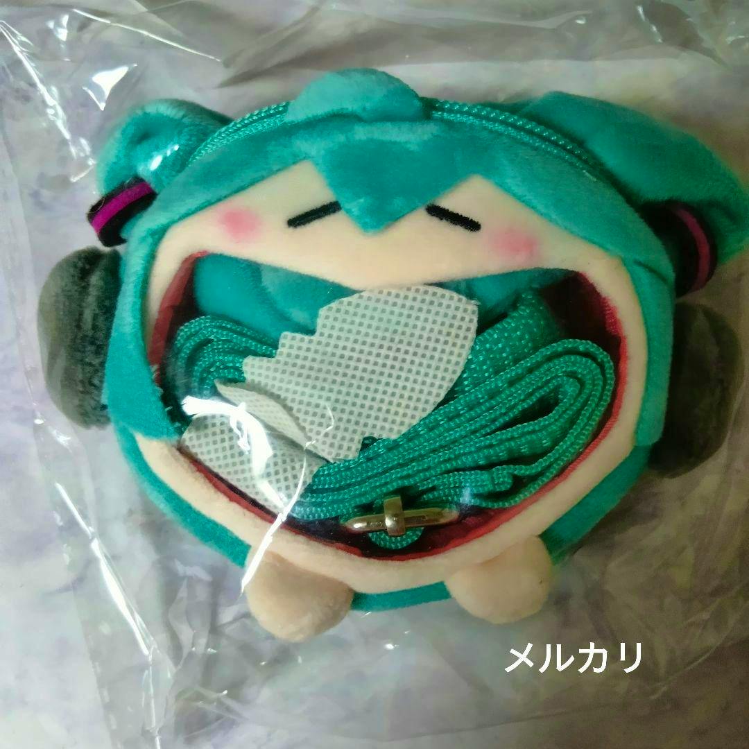 Teal Hatsune Miku character plush pouch with an open mouth zipper showing a coiled matching strap inside, pictured in plastic packaging.