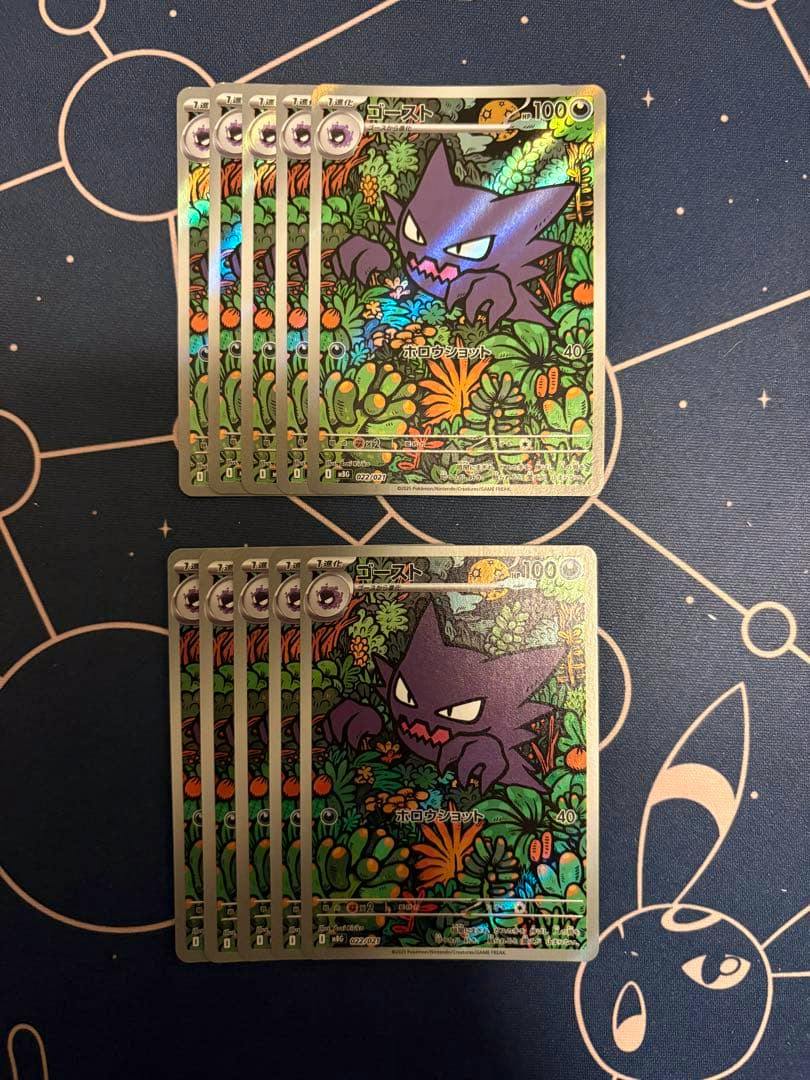 Ten holographic ghost-type trading cards featuring Gengar arranged in two stacks on a dark playmat.