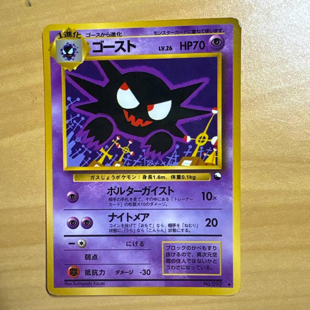 Front of a Japanese ゴースト LV.26 trading card showing the card artwork and printed Japanese text on a wooden background.
