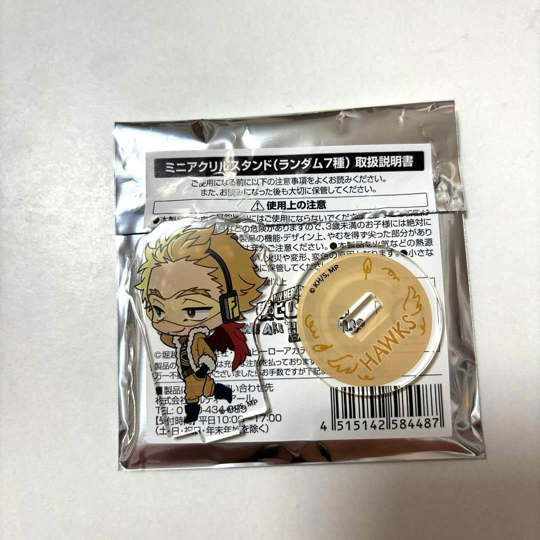 Sealed foil-backed package containing a Hawks mini acrylic stand with a chibi character acrylic figure and a round acrylic base labeled "HAWKS".