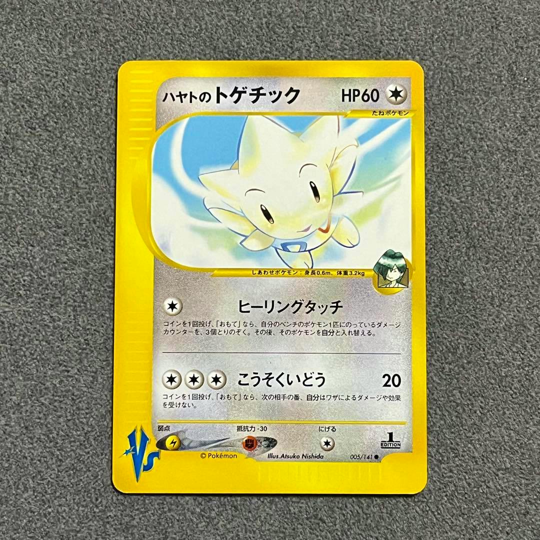 Front photo of the Japanese trading card "ハヤトのトゲチック" (005/141) showing the card artwork and text on a gray textured surface.