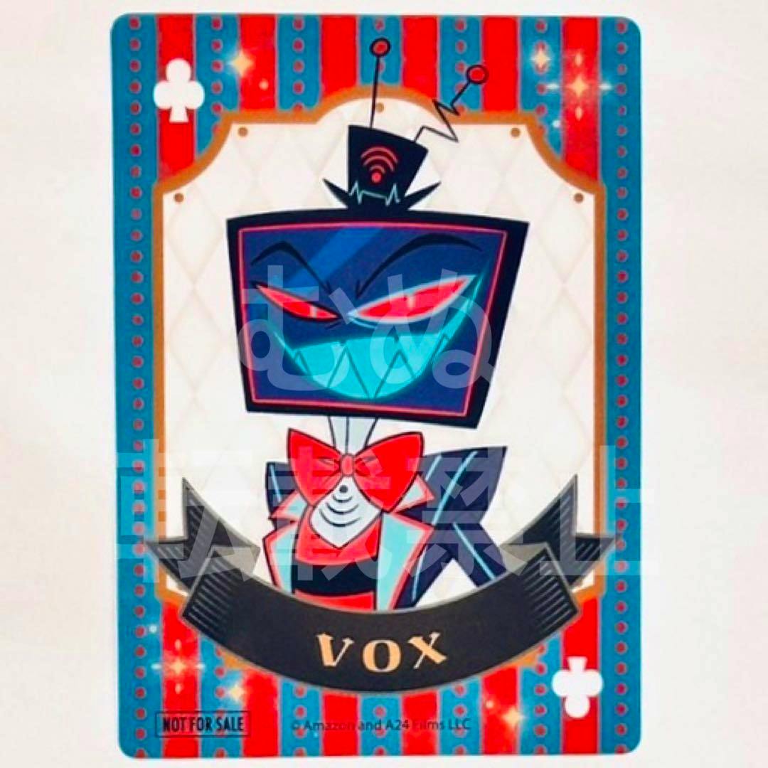 Photo of the Hazbin Hotel bonus clear plastic card showing the character Vox in a stylized playing-card design with a banner reading "VOX".