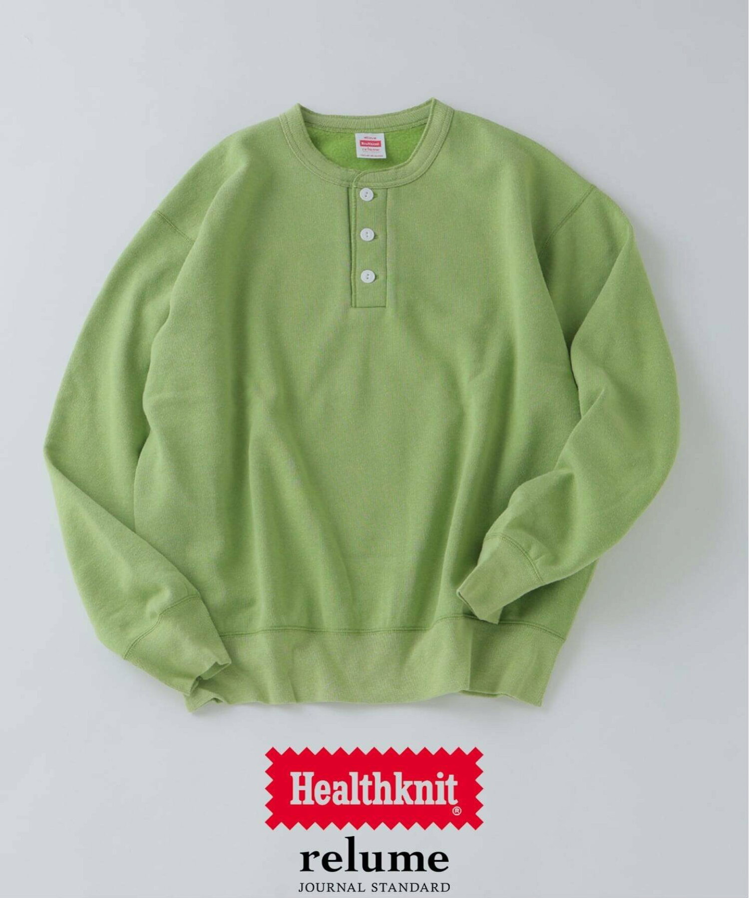 A green henley-neck cotton sweater laid flat showing the front and button placket.