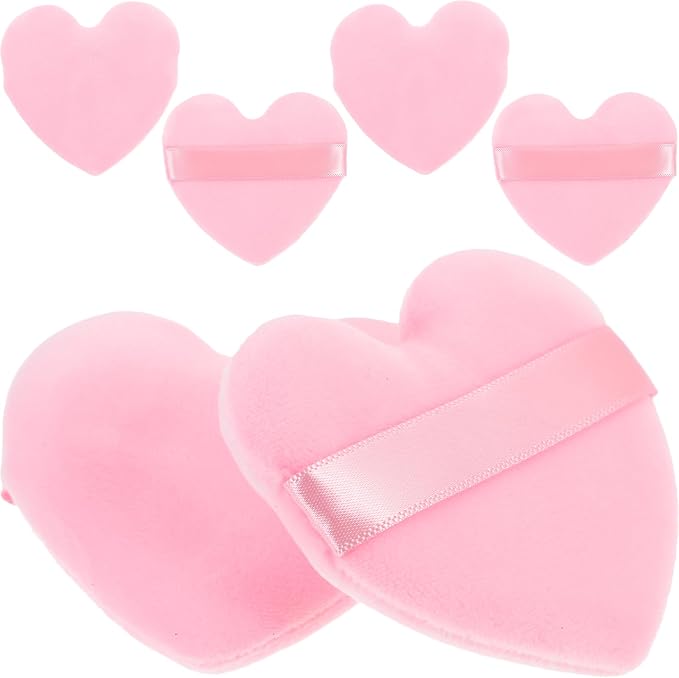 Pink heart-shaped flannel makeup powder puffs with ribbon finger straps on a white background.