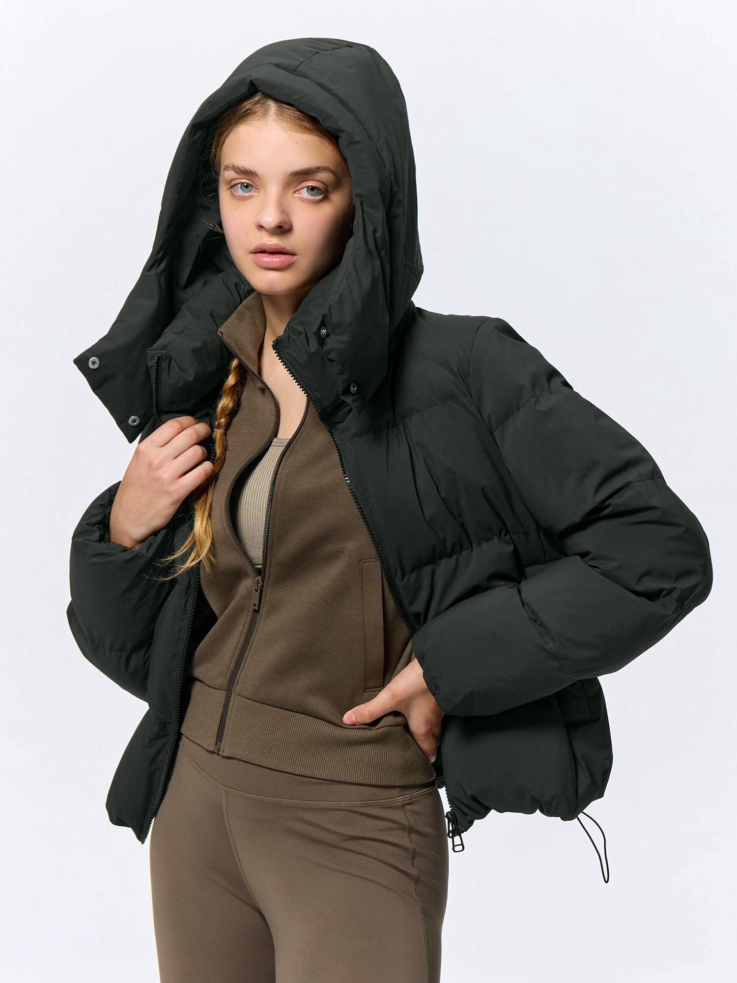 Model wearing the women's nylon heat-padded blouson jacket with the hood up, shown from the front.
