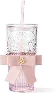 Clear glass drinking cup with lid and straw, embossed pattern, pink gradient base, and a pink decorative ribbon tied around it.