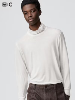 A model wearing the turtleneck from the product listing in white, shown from the waist up.