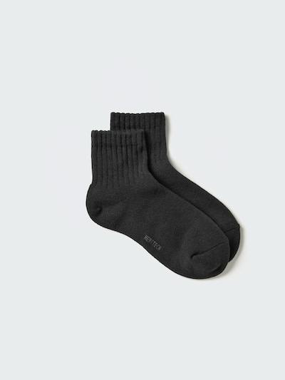 A pair of black Heattech half socks (pile) laid flat on a light background.