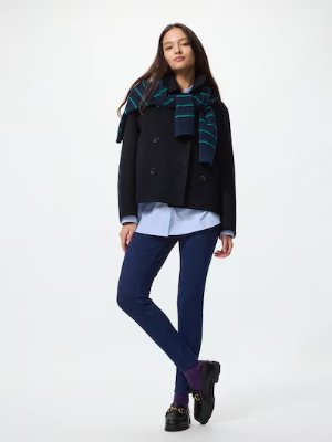 A model wearing blue leggings with a light-blue shirt and a black jacket against a white background.