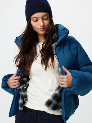 Model wearing a white long-sleeve crew-neck Heattech T visible under a blue jacket.