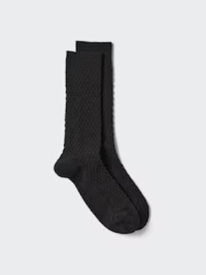 Black waffle-knit Heattech socks laid flat on a light background.