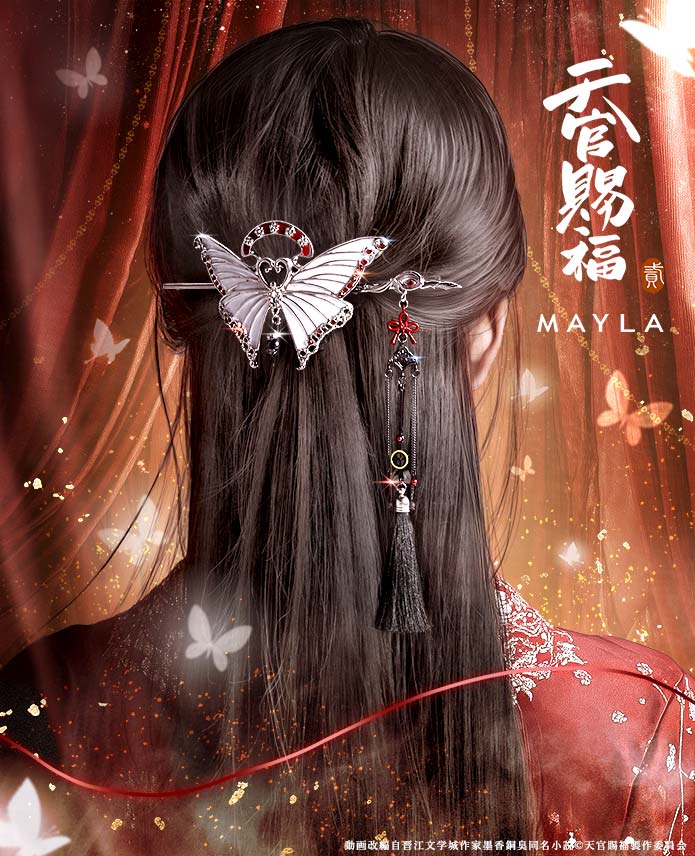Back view of long dark hair wearing a butterfly-shaped hair clip with a hanging tassel kanzashi charm.