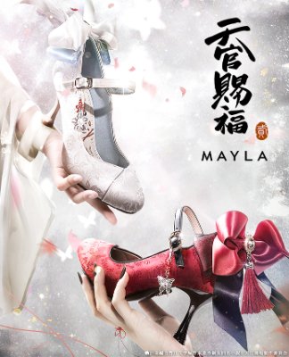 Two decorative women's pumps—one light-colored and one red with a large bow—being held by hands.