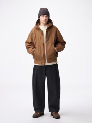 Male model shown full-length wearing black barrel-leg cotton pants on a plain white background.