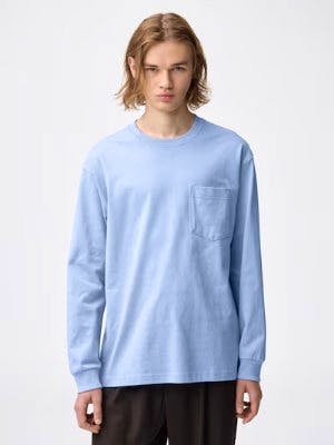 Model wearing a light blue long-sleeve crew-neck T-shirt with a chest pocket.