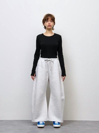 Front view of a model wearing the women's heavy-weight sweat 3D barrel pants in light gray against a plain wall.